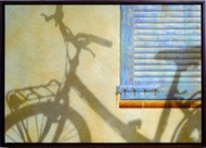 : Summertime: cycle beside ochre shutter 